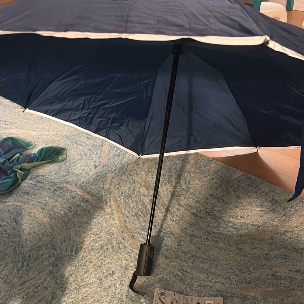 Revers-a-Brella. Brand new reversible umbrella navy blue with tags attached.